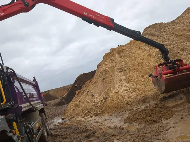 Grab lorry hydraulic arm loading soil on a Ringwood area job