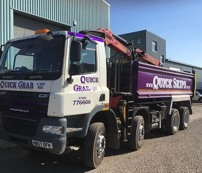 Quick Skips grab hire lorry loading waste on site in Ringwood, Dorset